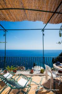 patio z krzesłami i widokiem na ocean w obiekcie Pensione Maria Luisa w mieście Positano