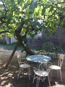 Saint Paul le Marseillais Gites في ميزيه: طاولة وكراسي يجلسون تحت شجرة