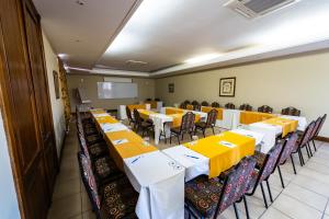 a conference room with tables and chairs and a screen at Gooderson Kloppenheim Country Estate in Machadodorp +124 photos