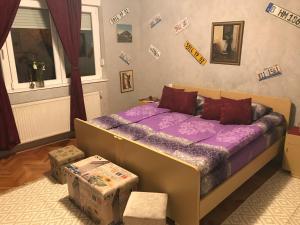 ein Schlafzimmer mit einem Bett mit einer lila Bettdecke in der Unterkunft Ruta 34 in Gornji Milanovac