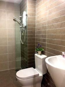 a bathroom with a toilet and a sink at Arena SOHO at Kozi Square Kuching in Kuching