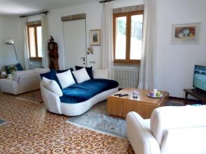 ein Wohnzimmer mit einem blauen Sofa und einem Tisch in der Unterkunft Casale La Pineta in Mombaroccio