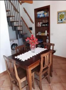 stół jadalny z wazonem kwiatów w obiekcie Appartamento relax Stefania w mieście Perdaxius