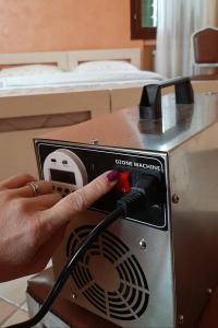 a person is plugging a cord into a machine at Hotel La Selce in Monselice