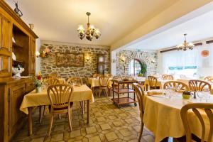- un restaurant avec des tables et des chaises dans une salle dans l'établissement Hôtel Restaurant Le Grillon, à Chambon-sur-Lac