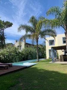 einen Hinterhof mit einem Pool und Palmen in der Unterkunft Entre Faros in Punta del Este