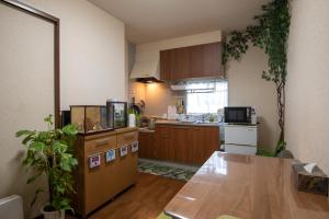 a kitchen with wooden cabinets and a wooden table at Garden Nikko Guest House in Nikko