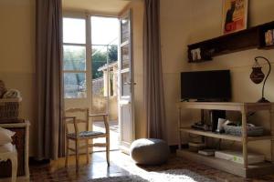 ein Wohnzimmer mit einem TV und einer Glasschiebetür in der Unterkunft St Jean du Gard : Spacious Apartment with Use of Pool in Saint-Jean-du-Gard