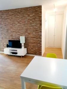 a living room with a white table and a tv at Center of Lisbon - University City in Lisbon