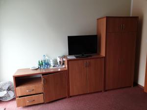 a room with a television and a wooden cabinet at Apartamenty Donald in Krynica Morska