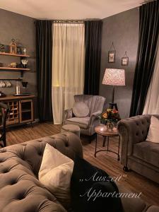 a living room with a couch and a chair at Auszeit-Appartement Wernigerode in Wernigerode