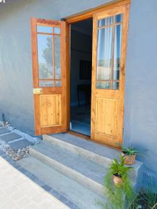 una porta aperta in legno su una casa con scale di Bonne Chance Cottage a Paarl
