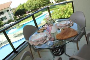 a table with plates and glasses on top of a balcony at CARNEIROS BEACH RESORT AP 311 E in Praia dos Carneiros