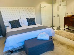 a bedroom with a large bed with two towels on it at Bonne Chance Cottage in Paarl