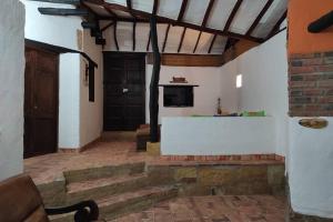 ein Wohnzimmer mit einem Tisch und einem TV an der Wand in der Unterkunft Casa Ceiba de Mirabel-Barichara in Barichara