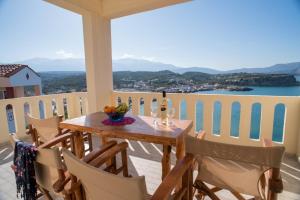 una mesa y sillas en un balcón con vistas en Villa Dina Apartments, en Almyrida