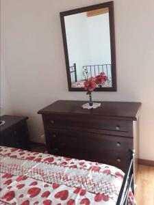 sypialnia z komodą z lustrem i łóżkiem w obiekcie Appartamento relax Stefania w mieście Perdaxius