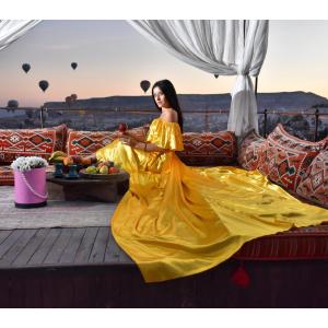 a woman in a yellow dress sitting on a couch at Emit Cave Hotel in Goreme