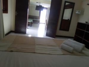 Una cama en una habitación con toallas. en Flat Vila 4 Amigos, en Natal