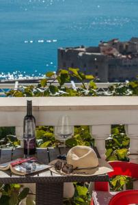 a table with a hat and a bottle and a glass at Amazing view Apartment and Rooms Dragan in Dubrovnik