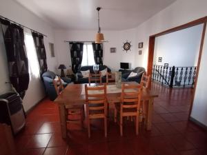 a living room with a wooden table and chairs at Casa Pôr do Sol in Mosteiros