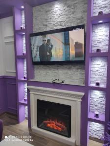 a fireplace with a flat screen tv above it at VIOLET QUEEN in Kopaonik