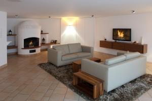 a living room with two couches and a fireplace at Hotel am alten Park in Augsburg