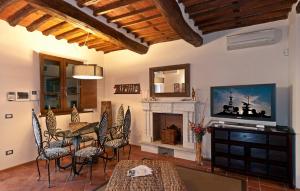 a living room with a table and chairs and a television at Residence Prunali in Massarosa