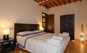 a bedroom with a large white bed with towels on it at Residence Prunali in Massarosa
