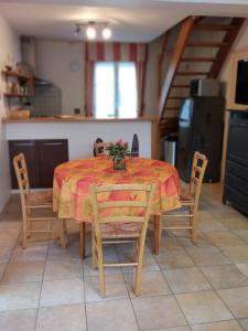 una mesa de comedor con un mantel rojo y sillas en Gites 10km de Granville, Hudimesnil, en Hudimesnil