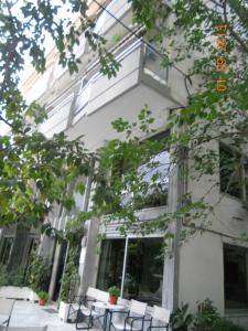 a building with tables and chairs in front of it at Rex Chasioti in Loutra Ipatis