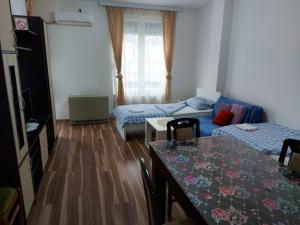 a living room with a table and a bed and a couch at Adam' s Apartment 3 in Kladovo