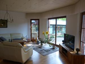 a living room with a couch and a tv at Auf der Heide in Borkheide
