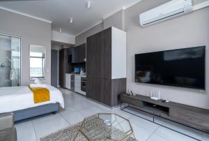 a bedroom with a bed and a large television at Top Floor Menlyn Maine studio apartment with Stunning Views & No Load Shedding in Pretoria