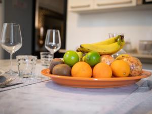 カリアリにあるSnob Luxury Suiteのワイングラス付きのテーブルに盛られたフルーツボウル