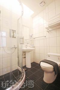 a bathroom with a toilet and a sink and a shower at 樂客2館 in Hsia-shih