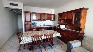 una cucina con tavolo, sedie e bancone di Appartamento Paradiso Azzurro a Porto Recanati