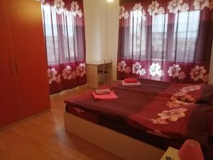 ビャラにあるMiranis Housesのベッドルーム1室(赤いシーツと窓付きの大型ベッド1台付)