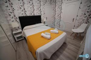 a bedroom with a bed with two towels on it at Apartment muy céntrico y diseño moderno 7' Laurel Vivienda de uso Turístico in Logroño