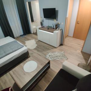 ザラカロシュにあるOrchidea apartmanのリビングルーム(ベッド1台、テレビ付)
