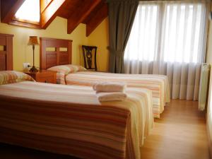 two beds in a hotel room with towels on them at Apartamentos Casa Cecilia in San Juan de Plan