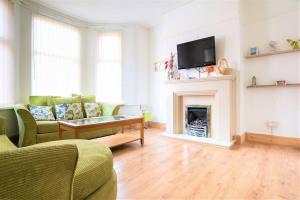 a living room with a couch and a fireplace at Charming 4-Bed Pet Friendly House in Liverpool in Liverpool