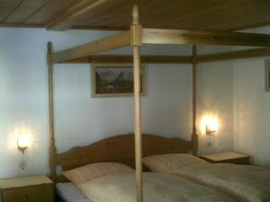 1 dormitorio con 1 cama con dosel y 2 lámparas en Haus Alpenblick inkl. Chiemgaukarte, en Ruhpolding