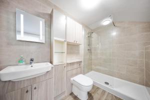 łazienka z umywalką, toaletą i wanną w obiekcie Inspire Homes - Joe's Cottage w mieście Southam