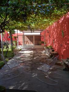 Cuatrociénegas de Carranza的住宿－Casita Felixz，一组椅子坐在一个有红色墙壁的庭院里