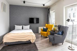 a bedroom with a bed and two chairs and a tv at apartamenty-wroc Kurkowa 14 in Wrocław