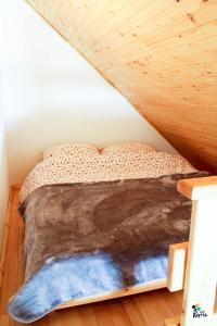 a bed in a room with a wooden ceiling at Apartman Adria 2 in Kupres