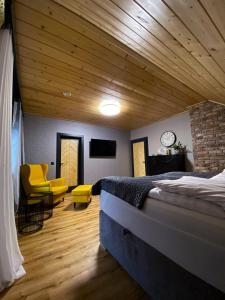 a bedroom with a bed and a couch and a clock at Międzybrodzie Bialskie Apartamenty Nowy Świat in Międzybrodzie Bialskie