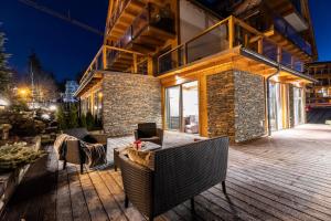 a building with a table and chairs on a deck at POD SKOCZNIA SPA Zakopane in Zakopane