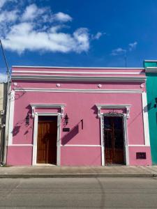 
a blue and white building with a pink door at Hotel & Hostal Boutique Casa Garza in Mérida
